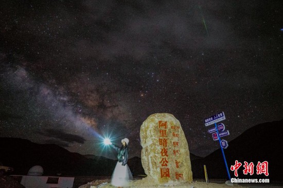 圖為6月20日晚，游客“打卡”西藏阿里暗夜公園，天上是銀河與流星（右上角）。曹枝清 攝