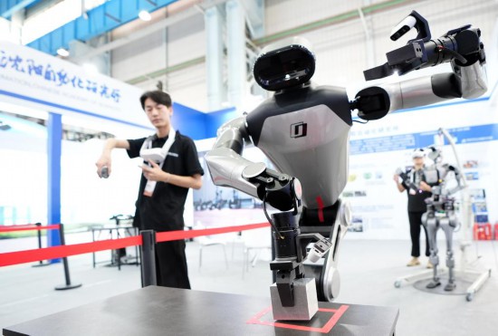 9月5日，在沈陽的2025全球工業(yè)互聯(lián)網(wǎng)大會的展覽區(qū)現(xiàn)場，中國科學(xué)院沈陽自動化研究所的機器人工程師在調(diào)試具身智能操作系統(tǒng)。新華社記者 李鋼 攝