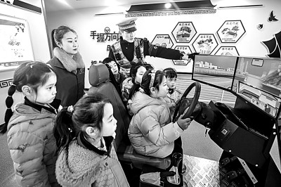 山東省榮成市公安局道路交通安全宣傳教育基地，交警帶領小學生現(xiàn)場體驗模擬駕駛。新華社發(fā)