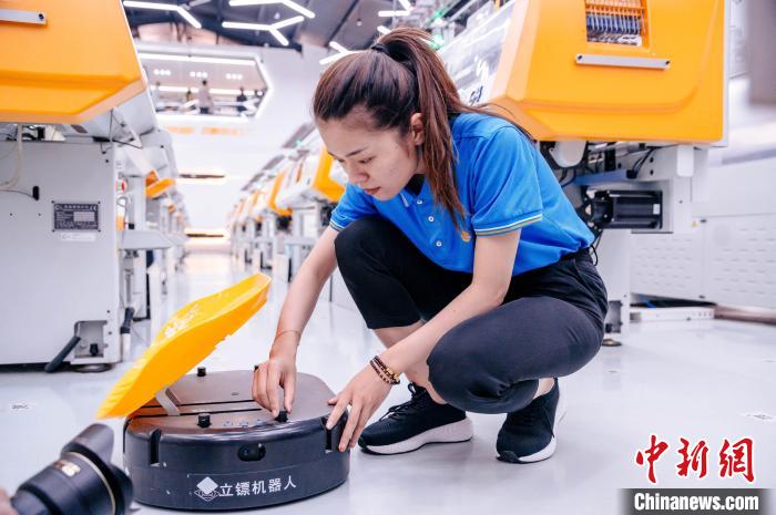 圖為員工在調(diào)試AGV搬運機器人?！±钅宪?攝